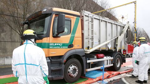 Reinigung und Desinfektion eines Tierkörperbeseitigungsfahrzeuges in einer Fahrzeugschleuse im Rahmen einer Tierseuchenübung. Mehrere Männer desinfizieren einen LKW in einer Desinfektionsschleuse