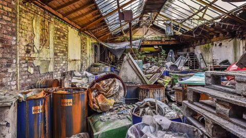 Sanierung eines ehemaligen Betriebsgeländes marode Halle gefüllt mit Abfall und Schrott