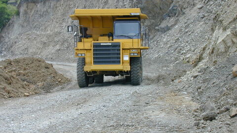 Achtung Schwerkraftwagen! Gelber Schwerkraftwagen zwischen Gestein