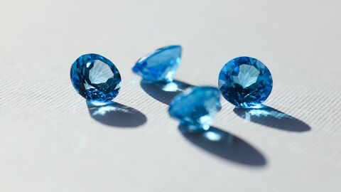 Hochwertige Güter Vier blaue Edelsteine auf weißem Grund
