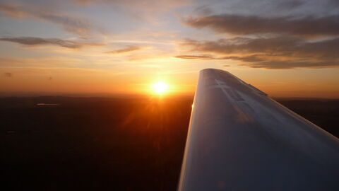 Tragfläche Blick aus dem Flugzeug auf die Tragfläche eines Flugzeuges mit einer untergehenden Sonne im Hintergrund