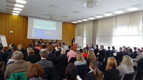 Menschen in einem Sitzungssaal bei einer Tagung