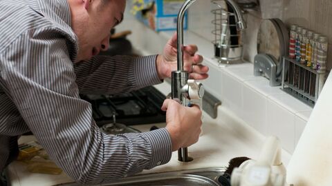 Klempner Klempner bei der Arbeit an einem Wasserhahn