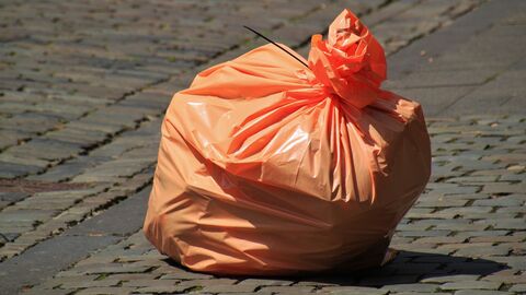 oranger Müllsack auf Kopfsteinpflaster 