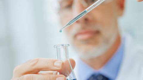 Labormedizinische Untersuchungen stehen für Qualitätssicherung Flüssigkeit wird mit einer Pipette in einen Erlenmeyerkolben gegeben