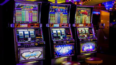 Spielhalle Drei bunt beleuchtete Automaten in einer Spielhalle