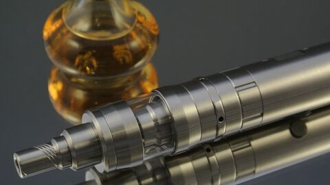 E-Zigarette Nahaufnahme einer E-Zigarette mit Liquid im Hintergrund