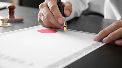 Unterzeichnung Nahaufnahme einer Person, die eine Urkunde unterzeichnet