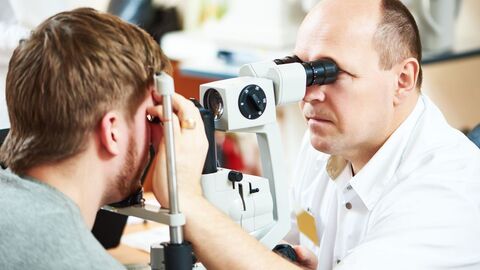 Arbeitsmedizinische Vorsorge dient der Früherkennung arbeitsbedingter Gesundheitsstörungen Augenarzt untersucht die Augen eines jungen Mannes