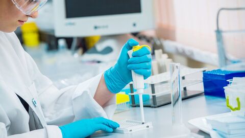 wirkstoffe_romaset_shutterstock_347539799 Eine Frau sitzt an einem Labortisch und pipetiert.