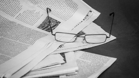 auf Zeitungen liegende Brille