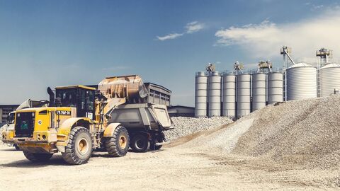 Ein Radlader füll Kies in einen LKW