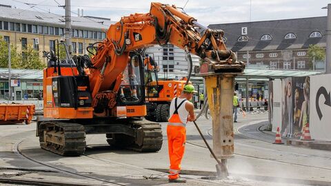 Baustelle mit Bohrbagger Ein großer Bohrbagger öffnet den Beton