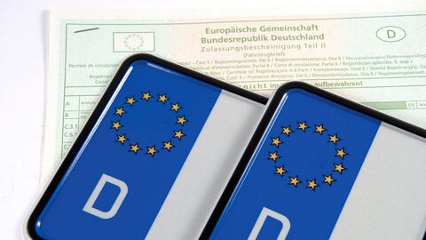 Straßenverkehrs-Zulassungs-Ordnung Zwei Kennzeichen liegen auf einem Zulassungsschein