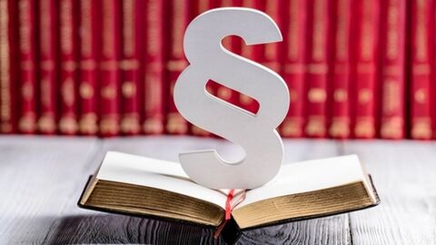 Aufgeschlagenes Buch mit Paragraphenzeichen Aufgeschlagenes Buch mit Paragraphenzeichen