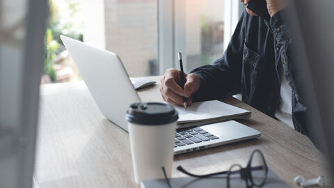 Ein Mann sitzt vor seinem Laptop und recherchiert im Internet