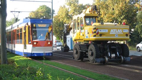 Eine Straßenbahn fährt an einem Bagger vorbei