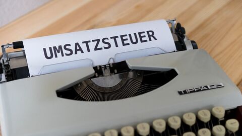 Eine Schreibmaschine mit einem eingespannten Blatt Papier, auf welchem Umsatzsteuer geschrieben steht.