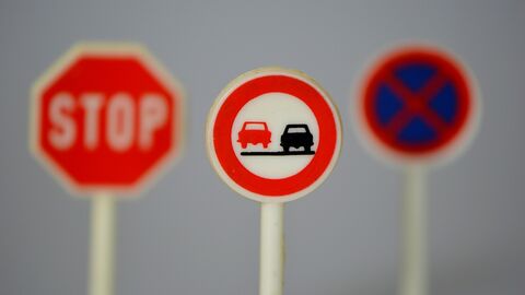 Straßenverkehrsordnung Ein Stoppschild, ein Überholen-Verboten-Schild und ein Absolutes-Halteverbotsschild stehen nebeneinander.