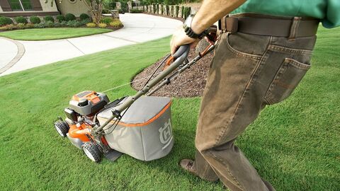 Rasenmäher Ein Mann mäht seinen Rasen