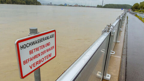 Hochwasseranlage Hochwasserschutzbecken bei hohem Wasserstand, Stadt im Hintergrund