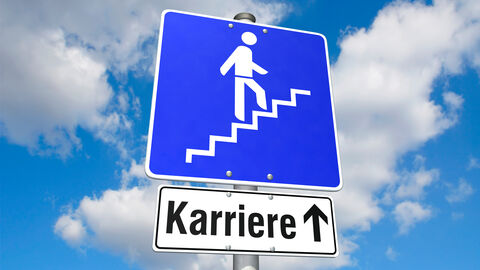 Ein blaues Schild, auf dem eine Person eine Treppe hochgeht mit dem Zusatz "Karriere" vor einem bewölkten Himmel