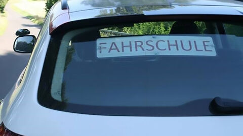 Nahaufnahme eines Fahrschulautos mit Hinweisschild