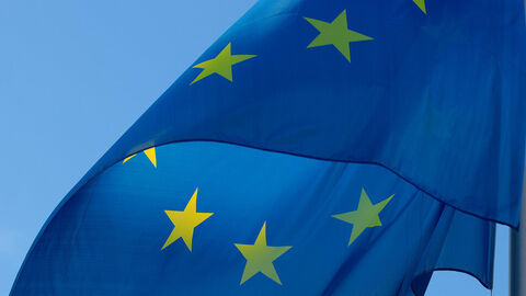 EU-Flagge Flagge der Europäischen Union weht vor blauem Himmel
