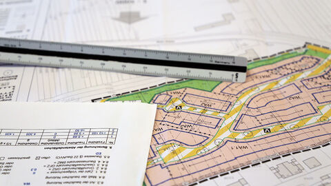 Bebauungsplan (Symbolbild) Verschiedene Baupläne und andere Papiere durcheinander, darüber ein Lineal
