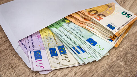 Bezahlung (Symbolbild) Offener Briefumschlag, aus dem mehrere 50-, 100-, 200- und 500-Euro-Scheine ragen