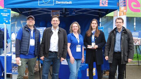 Von links nach rechts: ED-Leiter Matthias Schaider, Regierungspräsident Prof. Dr. Jan Hilligardt, ED-Mitarbeiterin Stephanie Müller-Dreieicher, Staatskanzlei-Referentin Hannah Wangard sowie OB Hanno Benz Fünf Personen vor blauem Stand