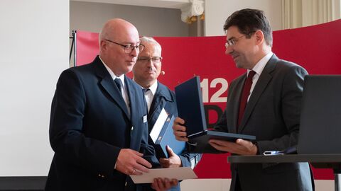 Drei Männer mit Plaketten