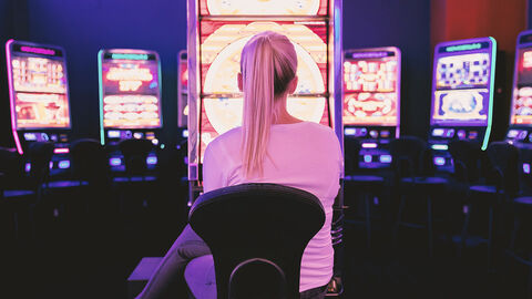 Glücksspiel (Symbolbild) Junge Frau im Spielcasino vor einem Spielautomaten