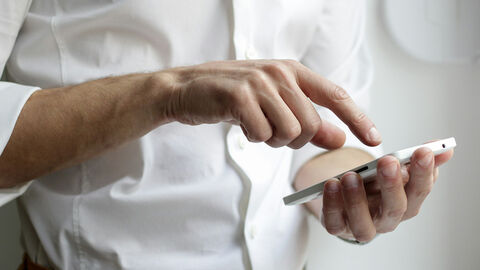 Online-Dienste (Symbolbild) Person tippt auf den Bildschirm eines Handys