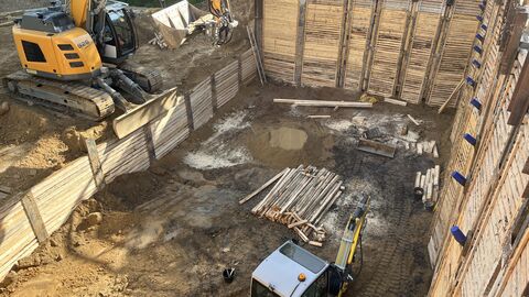 Baugrube mit Altlast Baugrube mit Baufahrzeugen