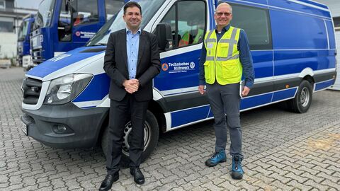 Zwei Männer vor blauem Lieferwagen