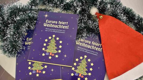 Drei blaue Bücher neben roter Mütze und Weihnachtsdeko