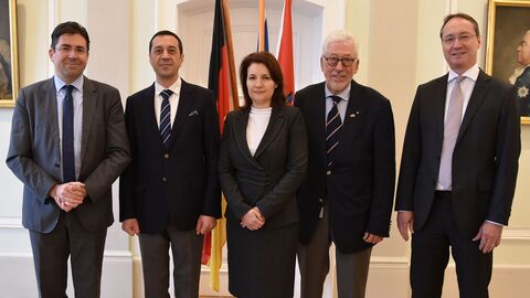 Botschafter der Republik Bulgarien im RP Vier Männer und eine Frau stehen nebeneinander und schauen in Richtung der Kamera. Sie stehen vor drei Fahnen: Einer EU-Fahne, eine Deutschland-Fahne und eine Hessen-Fahne.