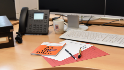 Orangefarbene Broschüre mit dem Titel Katastrophenalarm liegt an einem Arbeitsplatz