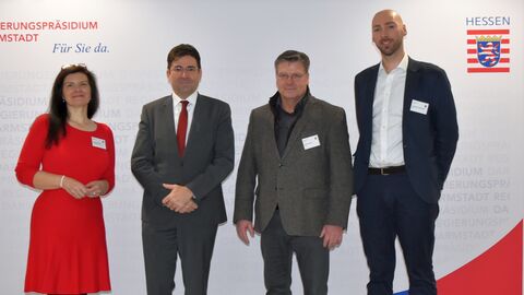 Vier Personen vor Stellwand