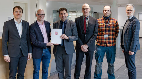 Genehmigung Heraeus Precious Metals Sechs Männer stehen nebeneinander und schauen in Richtung der Kamera.