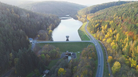 rechts und links bewaldetes Tal mit Stausee in der Mitte