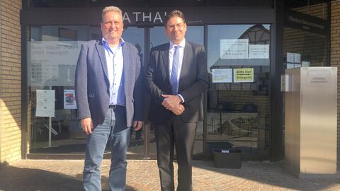 Zwei Männer vor Türeingang zu einem Gebäude