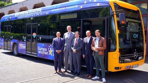 Europabus Fünf Männer stehen nebeneinander vor einem Linienbus.