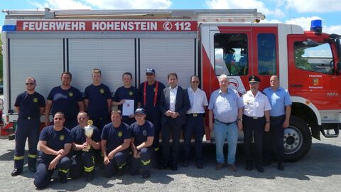 Feuerwehrleute stehen vor rotem Feuerwehrauto