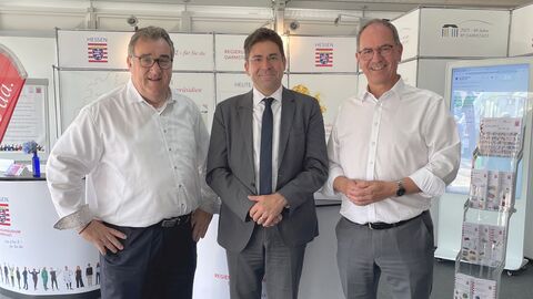 Die drei hessischen Regierungspräsidenten (v.l.n.r) Mark Weinmeister (RP Kassel), Prof. Dr. Jan Hilligardt (RP Darmstadt) und Dr. Christoph Ullrich (RP Gießen) am Dienstag am RP-Stand Drei Männer vor Stellwänden