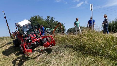 Bemannter Mähtraktor im Einsatz an Böschung