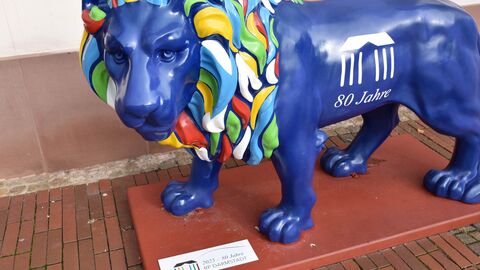 Der aufgehübschte Löwe vor dem Stammsitz des Regierungspräsidiums mit neuer Plakette Blaue Löwen-Skulptur