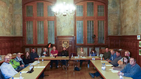 Informationsaustausch Ungefähr 20 Personen sitzen an U-förmig aufgestellten Tischen